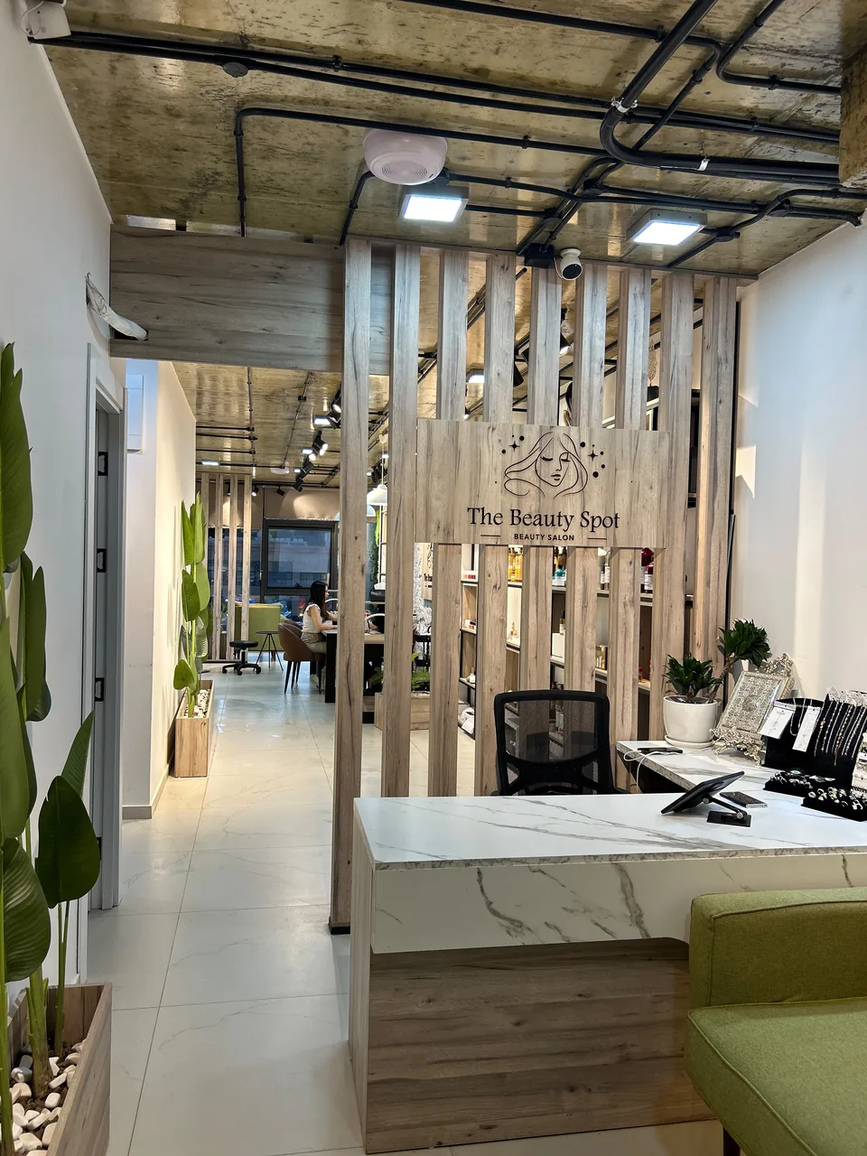 The warm wood reception and green salon interior at The Beauty Spot by Samah